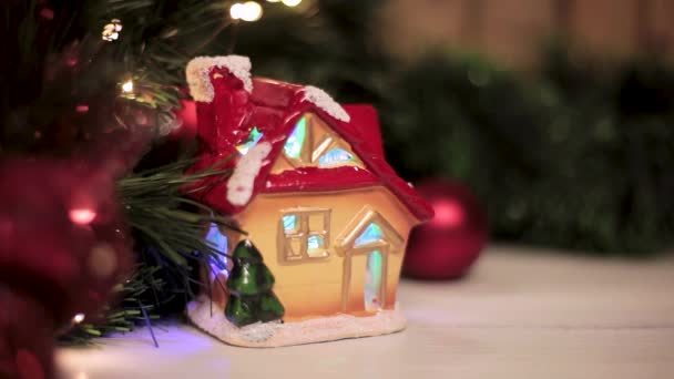 Рождественский Домик Красной Крышей Покрытый Снежными Вспышками Разноцветными Огнями Елкой — стоковое видео