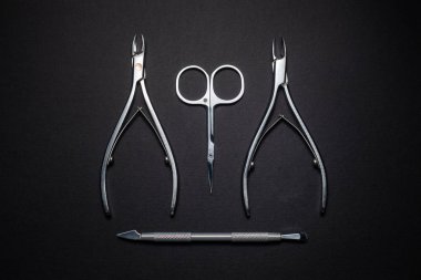 Manicure set of tools made of steel isolated on black background. clipart