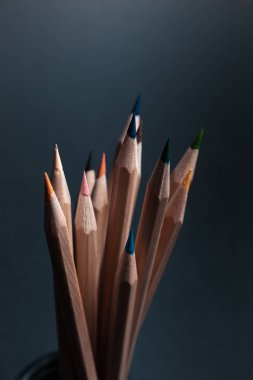 Siyah arka plan üzerine izole açık ahşaptan yapılmış farklı renklerde bilenmiş kalemler.