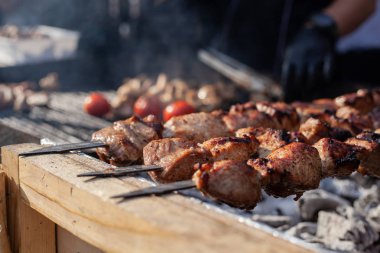 Şişli et siyah üniforma ve eldiven bir aşçı tarafından sıcak kömürler üzerinde pişirilir.