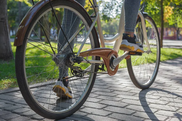 Una Chica Jeans Zapatillas Deporte Sienta Una Bicicleta Beige Parque —  Fotos de Stock