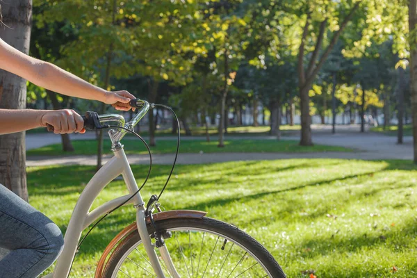 Uma Menina Jeans Tênis Monta Uma Bicicleta Bege Parque Entre Fotografias De Stock Royalty-Free