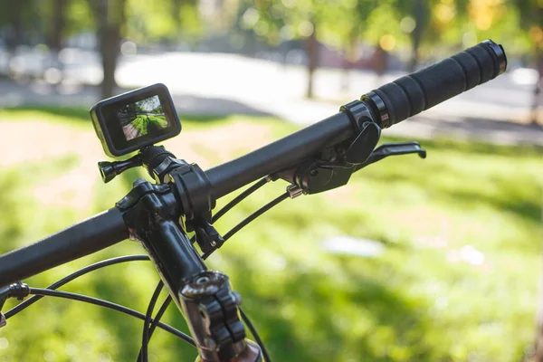 在公园里的自行车把手上装有屏幕的动作相机 — 图库照片