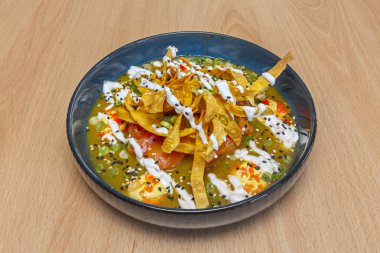 Taze siyah kabuklu Calaco tiradito, yoğun kaplan sütü ve kıyı kökenini vurgulamak için deniz kabuğunda servis edilen gevrek chifles.