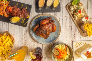 Kızarmış tavuk, yanında patates kızartması ve kızarmış sebzeyle büyük bir tabakta sunulur.