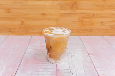 Instagrammable İçecek: Metal bir pipetle berrak bir bardakta buz Latte, karıştırmadan önce kahve ve süt katmanlarını gösterir