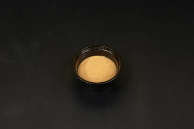 Wasabi mayonezli mini kaseler. Açık yeşil, Japon konteynırının siyah kenarıyla tezat oluşturuyor.