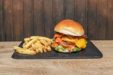 Klasik bir Amerikan hamburgeri, yumuşak brioche ekmeği, sulu sığır eti ve tüm geleneksel malzemelerle geliştirilmiş.