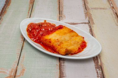 Morina keki, patates katmanları, kavrulmuş kırmızı biber, ve bchamel, altın olana kadar pişirilmiş.  