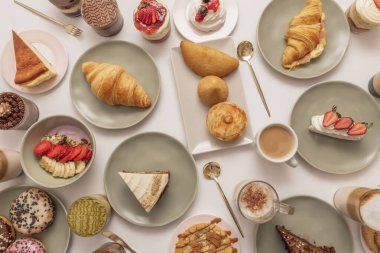 Akdeniz tatlılarının bir koleksiyonu: kabarık pasta katmanları, altın kunefe ve yer fıstığı serpiştirilmiş badem kurabiyeleri içeren baklava