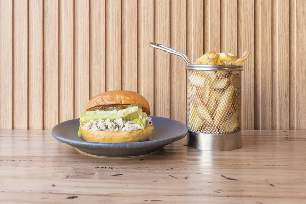 Bir hamburgerde lezzet patlaması: çörek, avokado ve ev yapımı mayonez, gündelik bir düzende.
