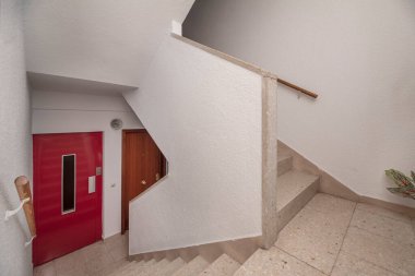 Üst katlar arasında merdiveni birleştirmek ve kaymayan yüzeylerle dokulu doğal taş basamaklar.