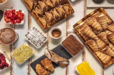 A central perspective of a chocolate fondue with fresh fruit, marshmallows, and brownies ready to be dipped