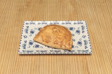 Tuna and tomato empanadas, traditional pastry, decorated with anchovies and black olives