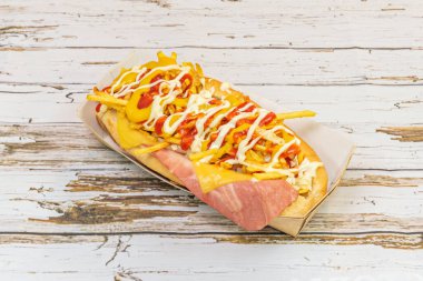 hot dog with chicken and herb sausage, basil pesto, sun-dried tomatoes, and grated Parmesan cheese