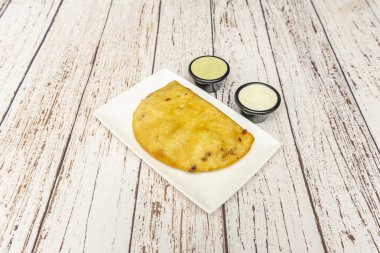 Shredded beef empanadas with Raisins and almonds, served with three sauces: guacamole, spicy salsa, and cilantro-lime salsa