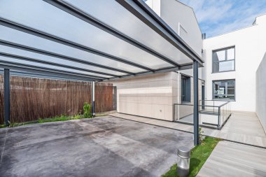 Bahçeye entegre edilmiş çimento döşemeli ve geceleri güneş ışığı alan park yeri..