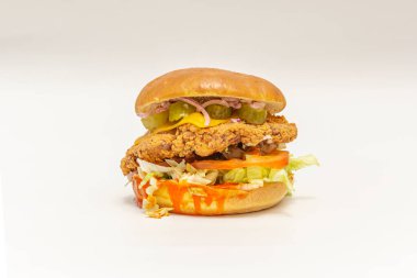 Peynirli çıtır hamburger, erimiş peynir, sarı armut domates ve deniz tuzu kristalli brioche ekmeği üzerine yabani yaprak karışımı.