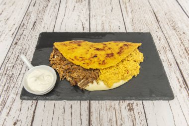 Kızarmış çavdar, haşlanmış tavuk, siyah fasulye ve kızarmış plantai dilimleriyle dolu gurme cachapa.