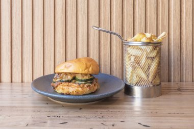 Biftek madalyonlu gurme burger, eritilmiş peynir, Raff domates ve kızarmış brioche ekmeğinde marul.