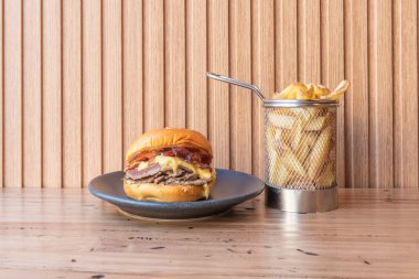 Kurutulmuş sığır eti, erimiş Gruyre peyniri, kalın dilimlenmiş domates ve Batavia marulu. 