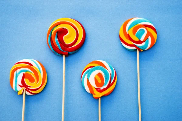 Барвистий льодяник на синьому фоні. Червоні, білі та сині смужки на цукерці. Мінімальна концепція. Серія цукерок . — стокове фото