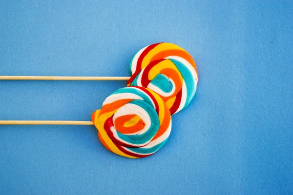 Colorful lollipop on a blue background. Red, white and blue stripes on a candy. Minimal concept. Candy shop series. — Stock Photo, Image