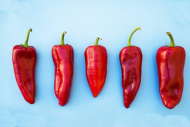 Mavi arka planda kırmızı kırmızı kırmızı biber, yakın plan.