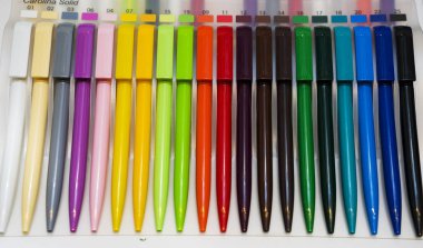 Beyaz masadaki çok renkli plastik tükenmez kalemler.