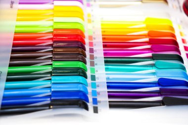 Beyaz masadaki çok renkli plastik tükenmez kalemler.