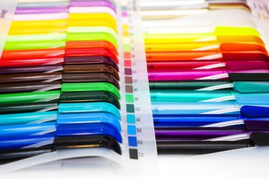 Beyaz masadaki çok renkli plastik tükenmez kalemler.