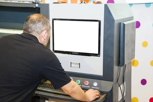 O operador em uma impressora de grande formato imprime uma foto — Fotografia de Stock