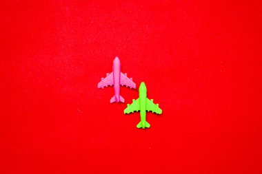 Flat lay of miniature toy airplane on pastel red background minimal trip and travel creative concepts. copy space