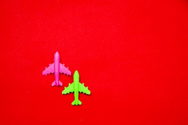 Flat lay of miniature toy airplane on pastel red background minimal trip and travel creative concepts. copy space