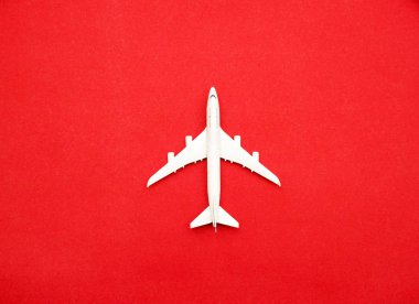 Flat lay of miniature toy airplane on pastel red background minimal trip and travel creative concepts. copy space