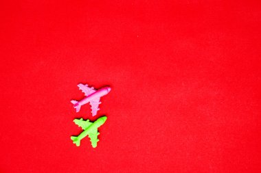 Flat lay of miniature toy airplane on pastel red background minimal trip and travel creative concepts. copy space