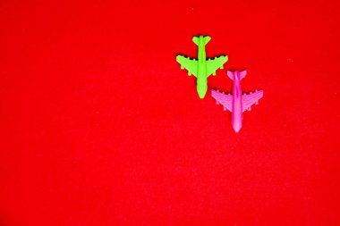Flat lay of miniature toy airplane on pastel red background minimal trip and travel creative concepts. copy space
