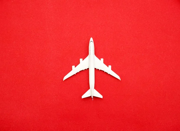 Płaskie Ułożenie Miniaturowego Samolotu Zabawki Pastelowym Czerwonym Tle Minimalna Podróż — Zdjęcie stockowe