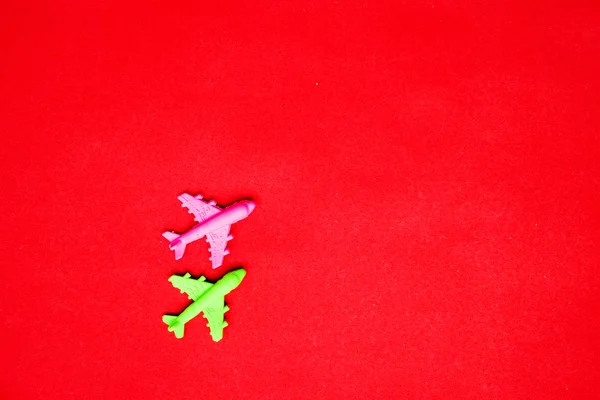 Posa Piatta Aeroplano Giocattolo Miniatura Sfondo Rosso Pastello Viaggio Minimo — Foto Stock