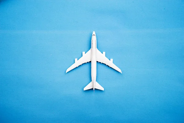 Flat lay de avião de brinquedo em miniatura em fundo azul viagem mínima e viajar conceitos criativos. espaço de cópia — Fotografia de Stock