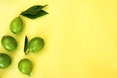 green lemons on yellow pastel background, concepts,summer ideas of fruit, vegetable, healthy eating lifestyle, flat lay,