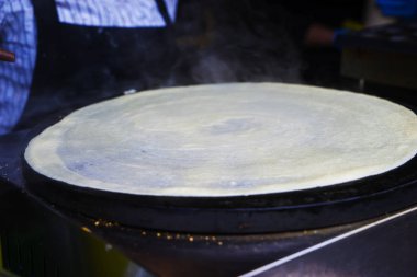 Kız krep yapan bir pasta şefi. Pişirme krepi yapmanın basamakları.