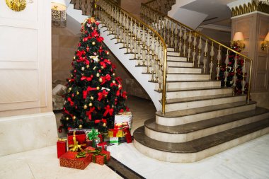 a beautiful Christmas tree with toys stands in the lobby.