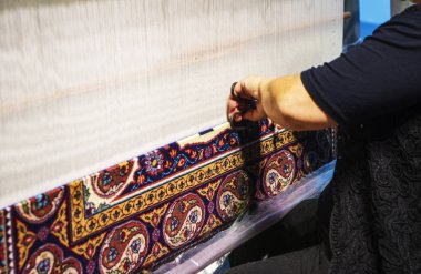 vrouw die werkt aan het weefgetouw. Oosterse moslim nationale ambachten. focus op de stof