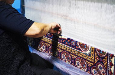 vrouw die werkt aan het weefgetouw. Oosterse moslim nationale ambachten. focus op de stof