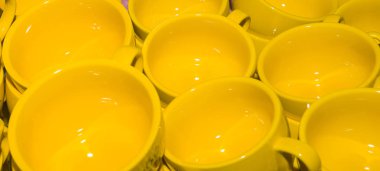 set of empty yellow coffee cups on the bar.