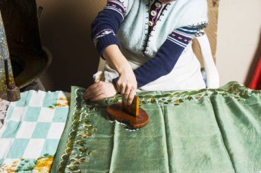 Kadın usta, çizimleri kalagay, oryantal, Türk ipek eşarplarına koyuyor..