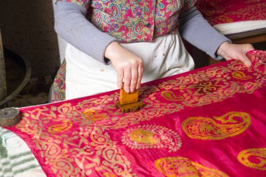 Kadın usta, çizimleri kalagay, oryantal, Türk ipek eşarplarına koyuyor..