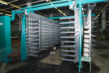 Fabrikadaki dokuma tezgahında beyaz ipek iplik..