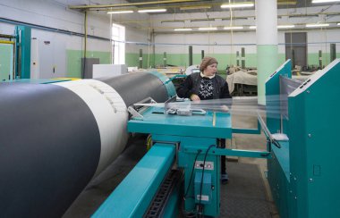 Bakü, Azerbaycan, 20 Şubat: Tekstil endüstrisi için renkli ipek ipliği üretmek için arka planda makine donanımı bulunan yakınlardaki fabrikada çalışan kadın işçiler.